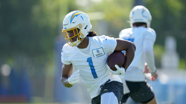 Jul 26, 2023; Costa Mesa, CA, USA; Los Angeles Chargers receiver Quentin Johnston (1) takes the handoff from quarterback Justin Herbert (10) during training camp at Jack Hammett Sports Complex. Mandatory Credit: Kirby Lee-USA TODAY Sports  